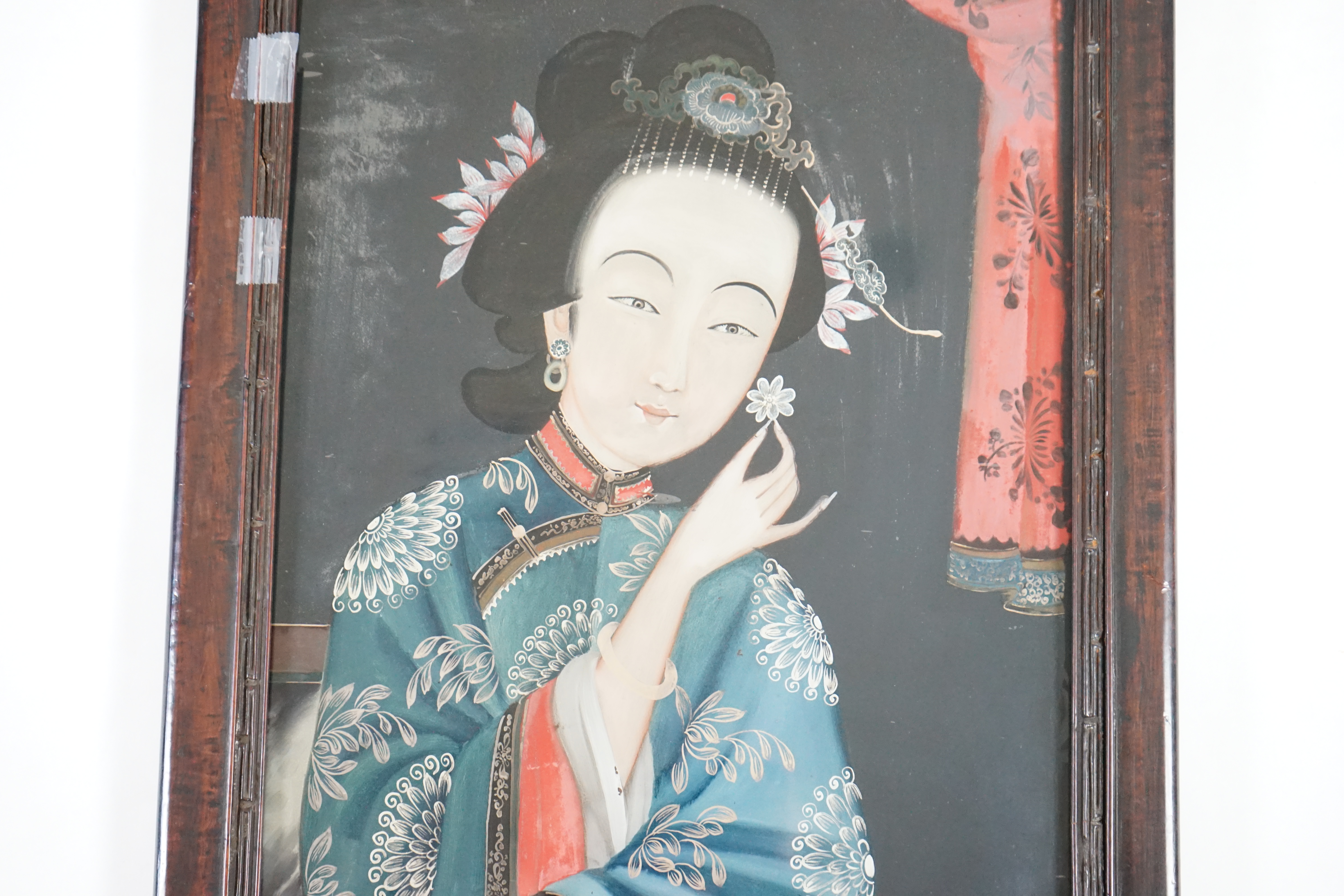 A Chinese reverse painting on glass of a lady holding a flower, 19th century